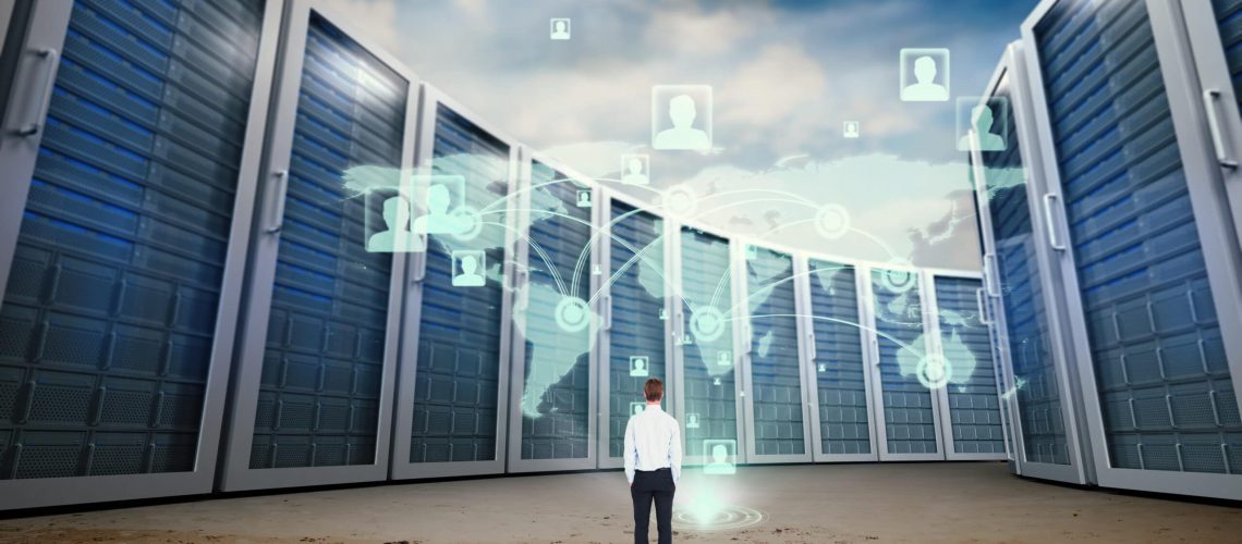 Rear view of businessman with hands in pockets in a big data center